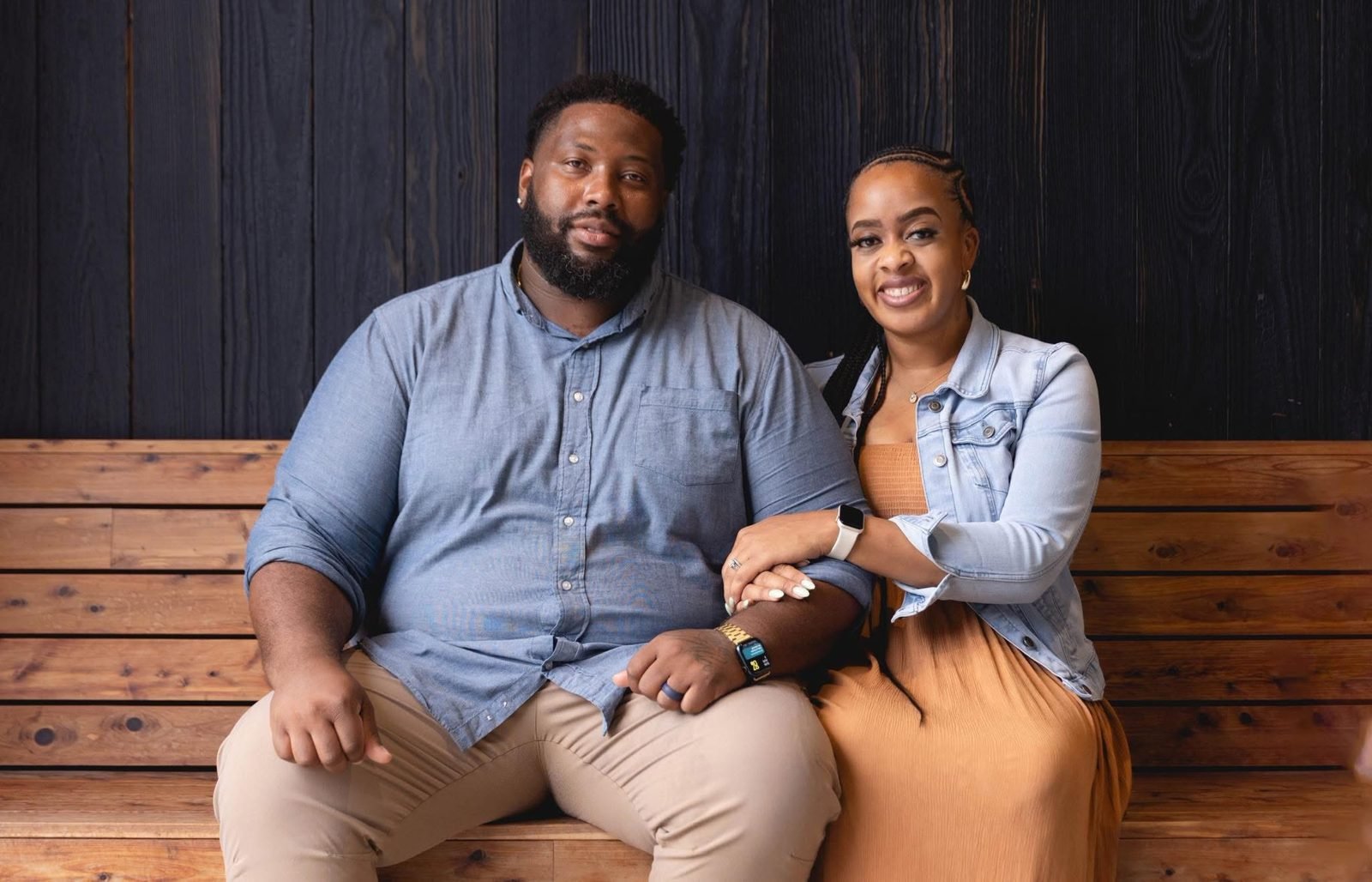 Alex and Kendra Cutler, owners of 121 Media Group, seated together on a wooden bench