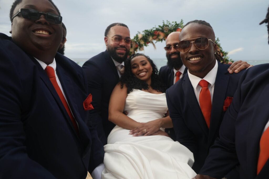 Groomsmen laughing with the bride in a fun wide-angle portrait — photographed by 121 Media Group