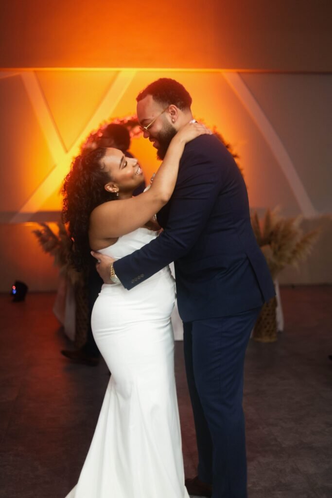 Couple's first dance in warm reception lighting — photographed by 121 Media Group