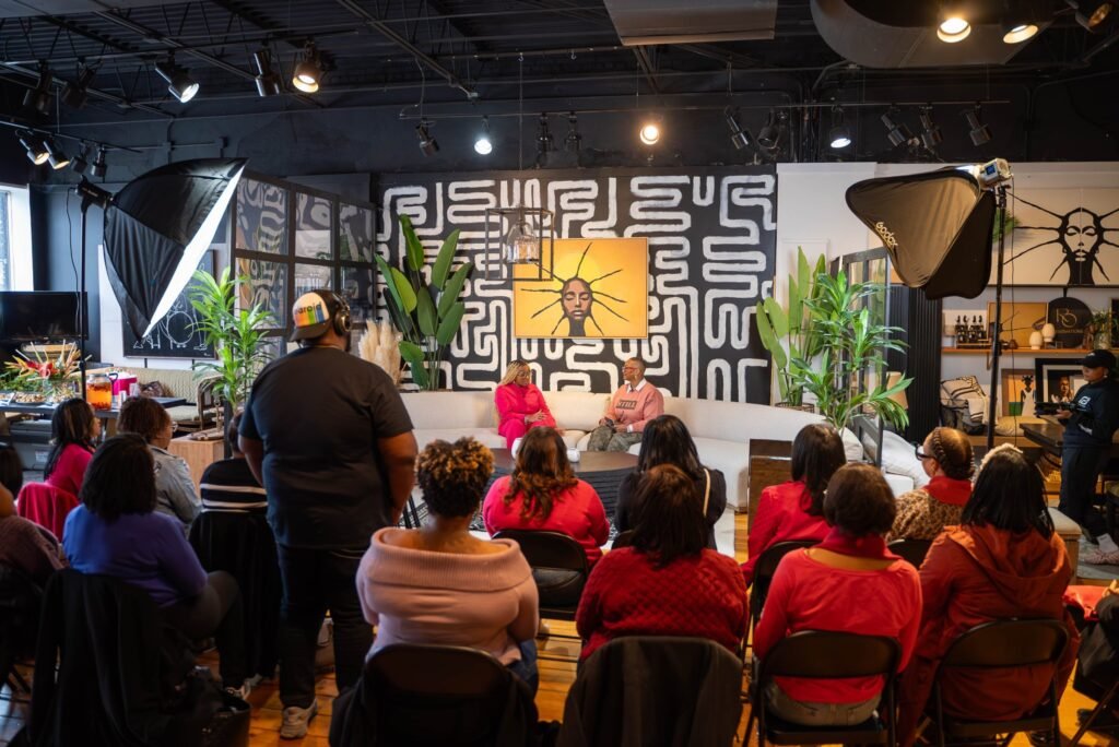 Wide shot of a live podcast audience facing the set and studio lighting — photographed by 121 Media Group
