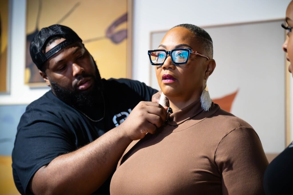 Crew member fitting a lavalier microphone on a podcast guest before recording — photographed by 121 Media Group