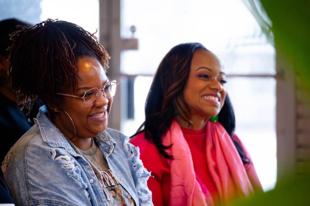 Audience members laughing during a live podcast taping — photographed by 121 Media Group