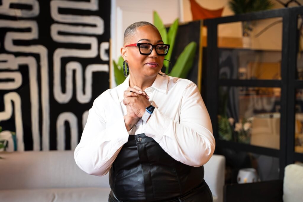 Podcast host seated on set adjusting her microphone — photographed by 121 Media Group