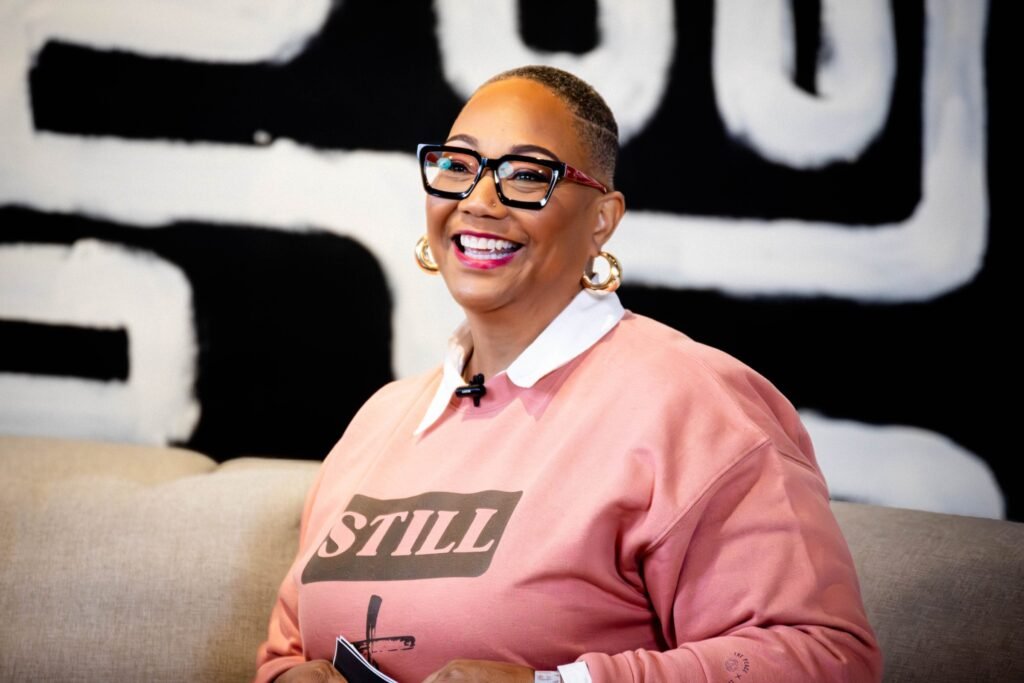 Smiling podcast guest seated on a white sofa — photographed by 121 Media Group