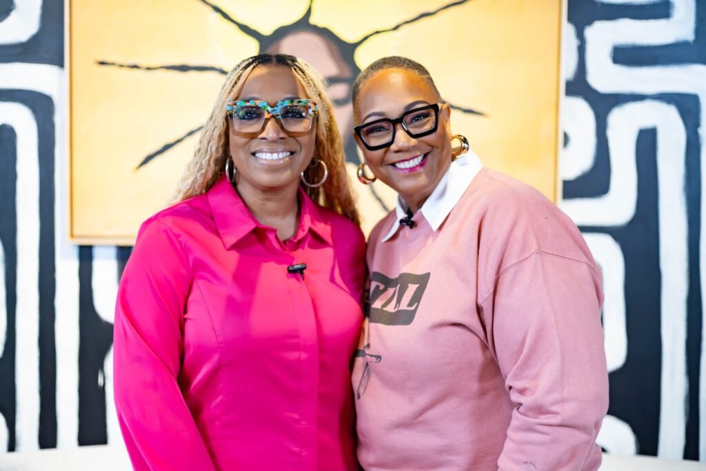 Two podcast guests in pink posing together on set — photographed by 121 Media Group