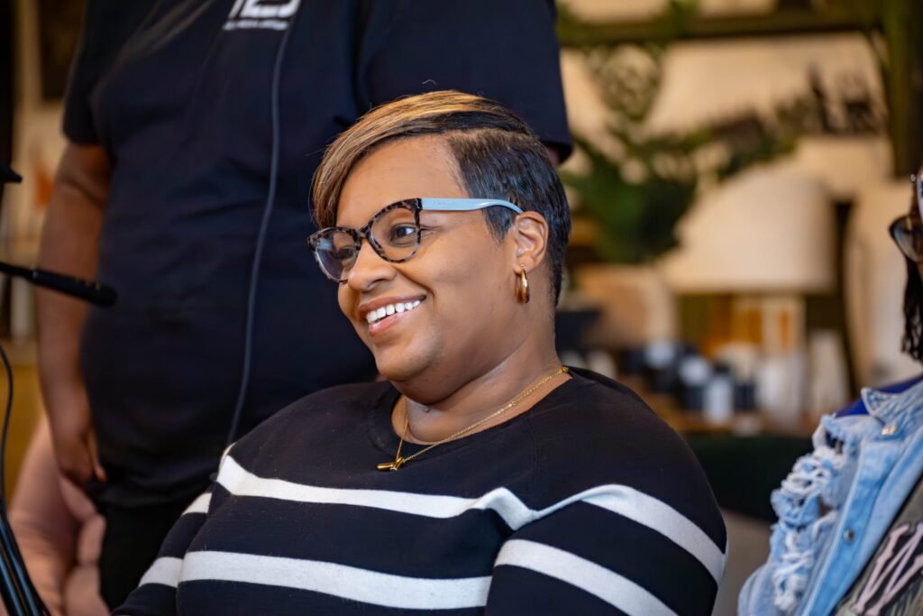 Audience member smiling during a live podcast taping — photographed by 121 Media Group