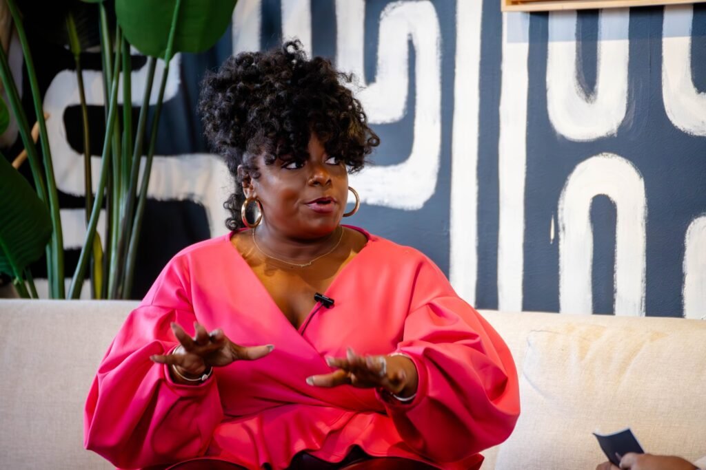 Podcast guest in pink speaking with expressive hand gestures — photographed by 121 Media Group